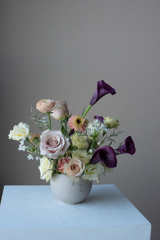 Centrepiece arrangement by May Flowers Florist, using purple calla lilies and other champagne flowers
